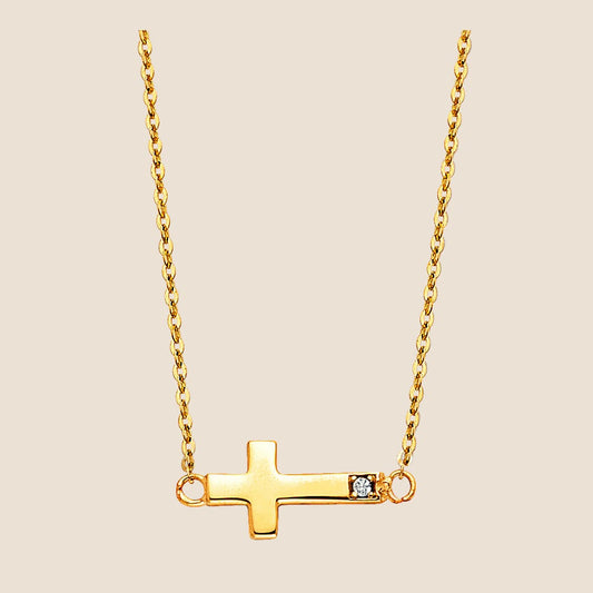 14k gold sideways cross necklace with sparkling accent stone on delicate chain, modern minimalist design, adjustable 17" + 1" length.